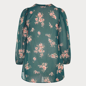 The back of an emerald green blouse with floral design and balloon sleeves.